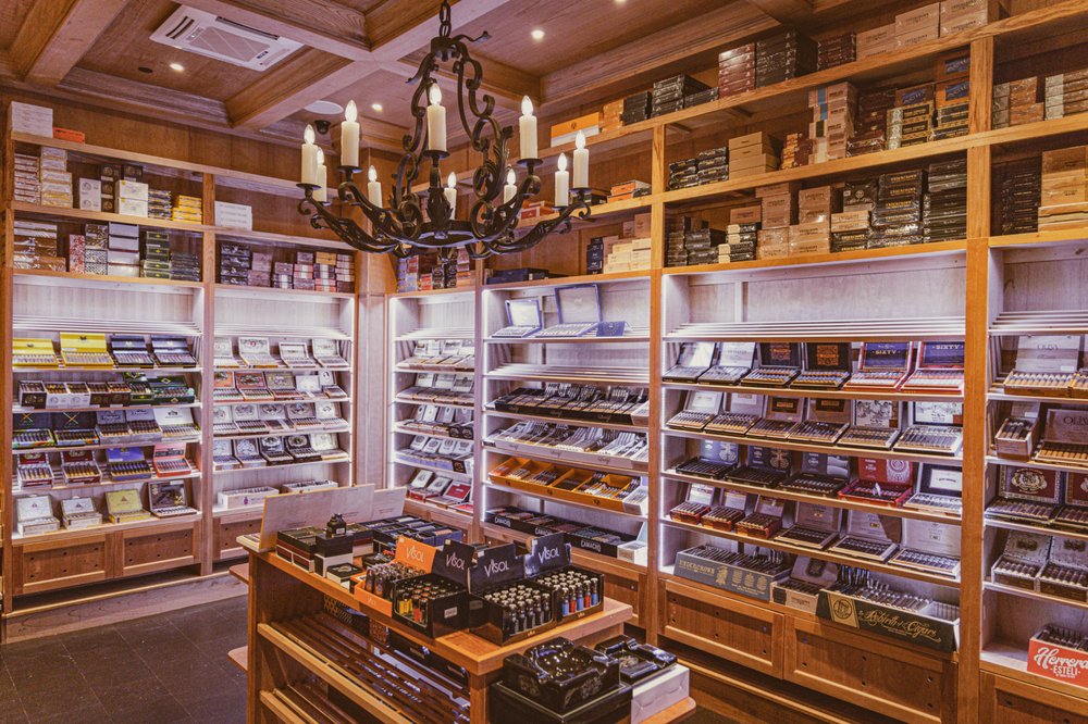 Wilde Cigars walk-in humidor with chandelier and open cigar boxes on wooden shelves