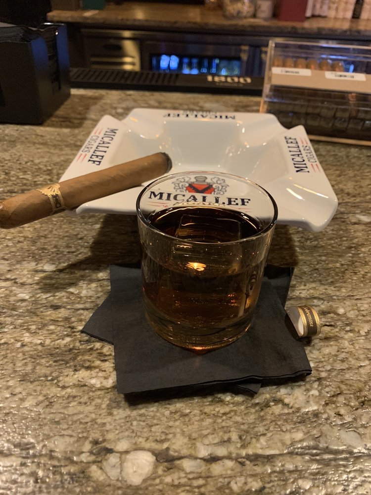 Whiskey pour and lit cigar on the bar at Wilde